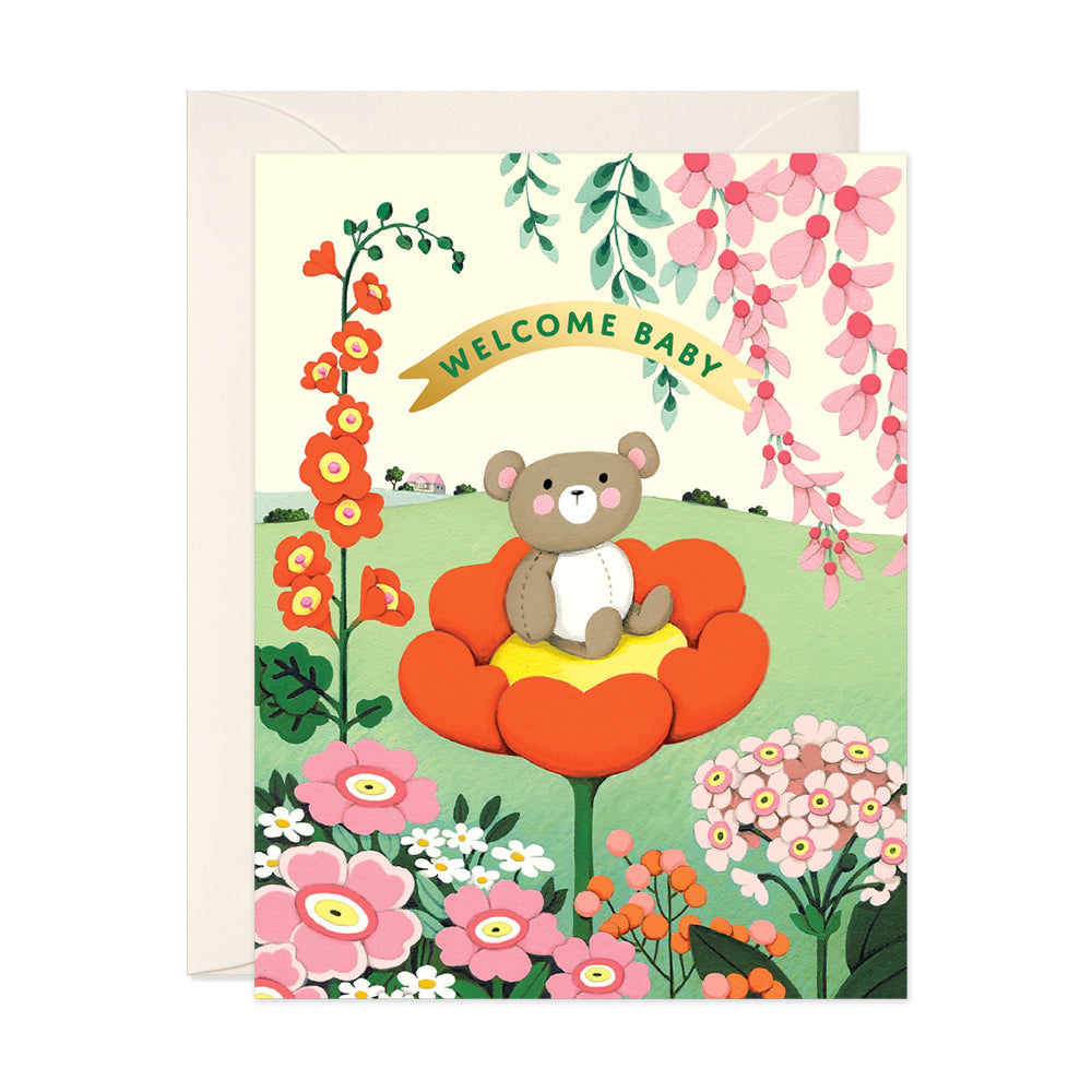 Teddy Bear sitting on a flower in a garden welcome baby greeting card