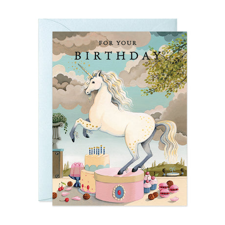 White unicorn with cake and macarons in a French garden happy birthday greeting card